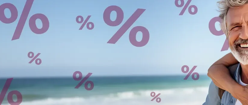 Lachendes älteres Paar am Meer umarmt sich, im Hintergrund sieht man Prozente. Angebote von Schuy Reisen.