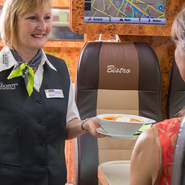 Bord-Stewardess serviert Suppe im Bistro Bus.
