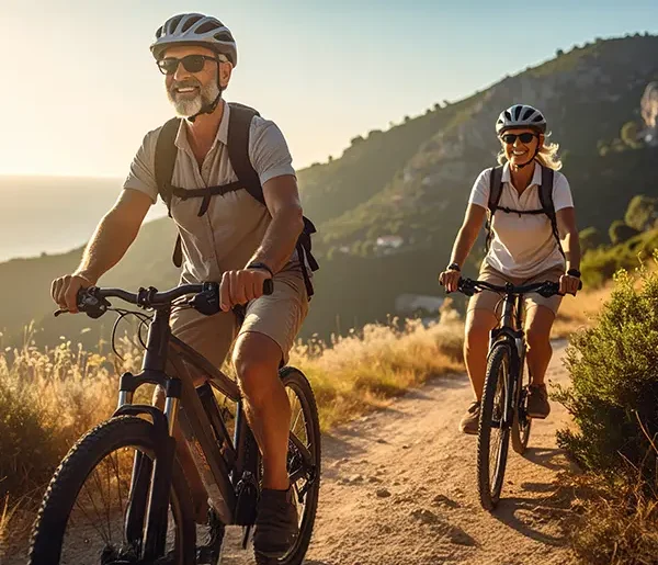 Zwei glückliche Radfahrer in traumhafter mediterraner Landschaft mmit Abendstimmung während einer Schuy Radreise.