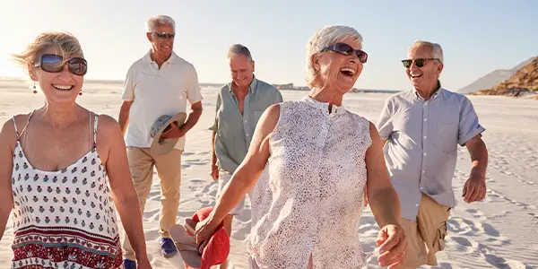 Glückliche Urlauber am Sandstrand während einer Urlaunsreise.