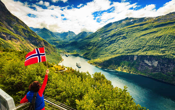 Tourist über Geirangerfjord mit norwegischer Flagge