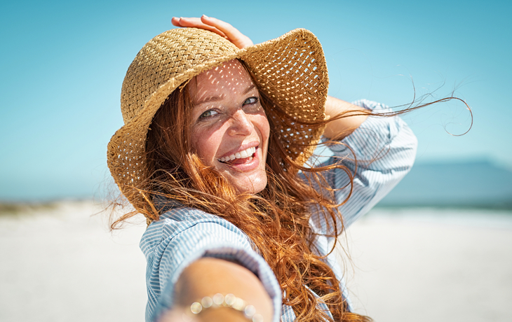 Lächelnde reife Frau mit Strohhut