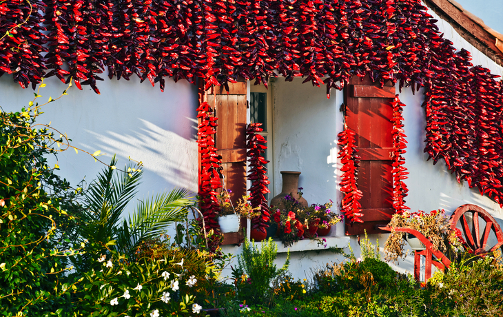 rote Espelette-Paprikaschoten schmücken ein baskisches Haus