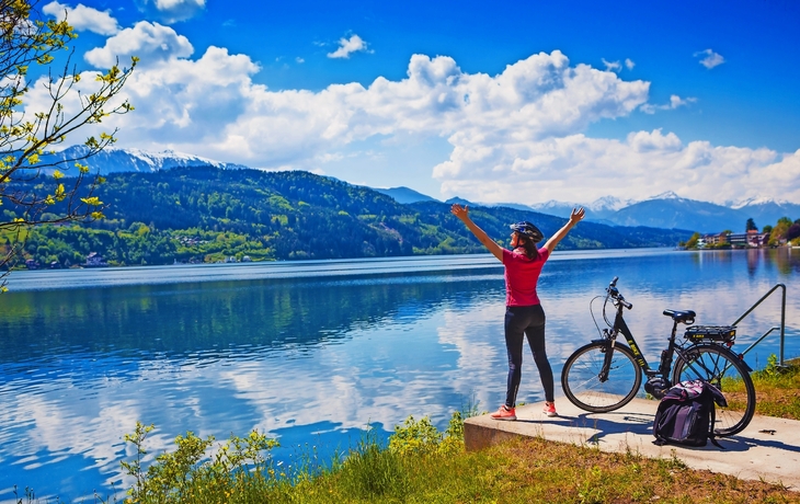 Frau mit E-Bike-Blick über den See-See und dem Fahrrad zu genießen 02