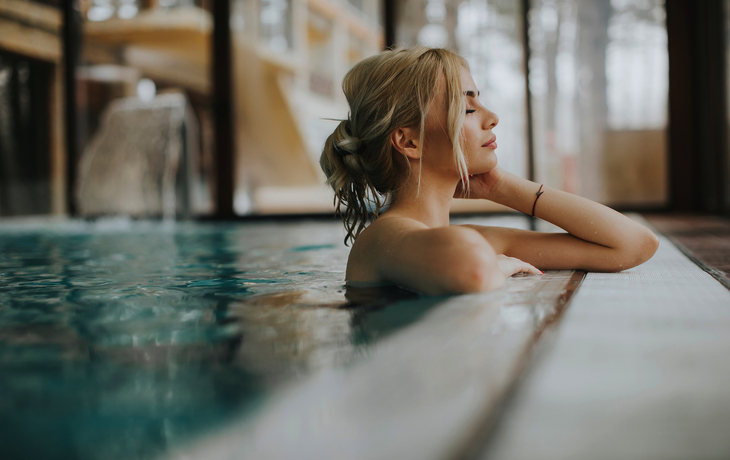 junge Frau, die sich im Spa-Schwimmbad entspannt
