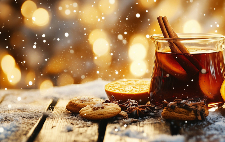 Glühwein mit Zimt, Orangenscheibe und Weihnachtskeksen